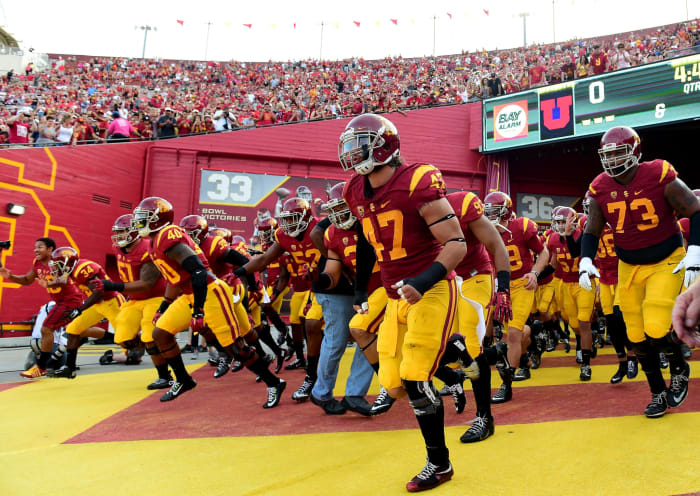 USC Football players running onto the field before a home game.