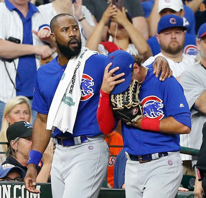 Albert Almora Jr. covers his face after accidentally hitting a fan with a foul ball.