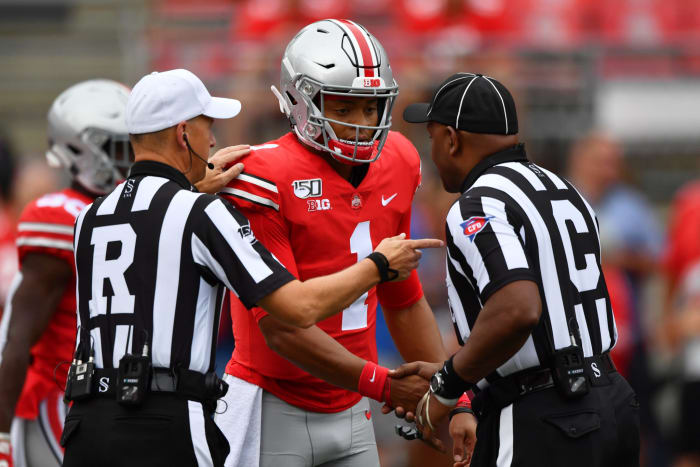 Ohio State quarterback Justin Fields meets with the Big Ten football officiating crew prior to kickoff.