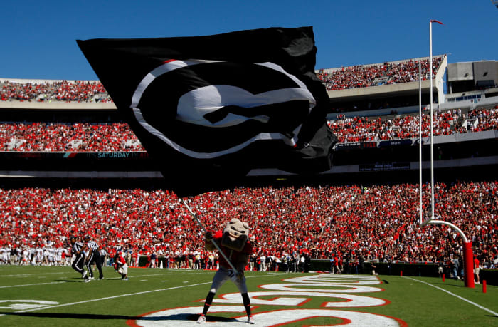 Georgia's mascot waving a Georgia flag.