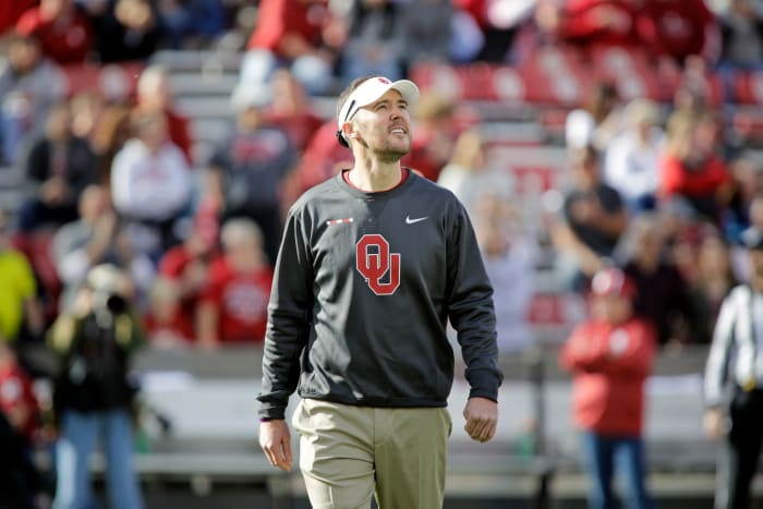 A closeup of Lincoln Riley wearing a grey Oklahoma sweater before a game.