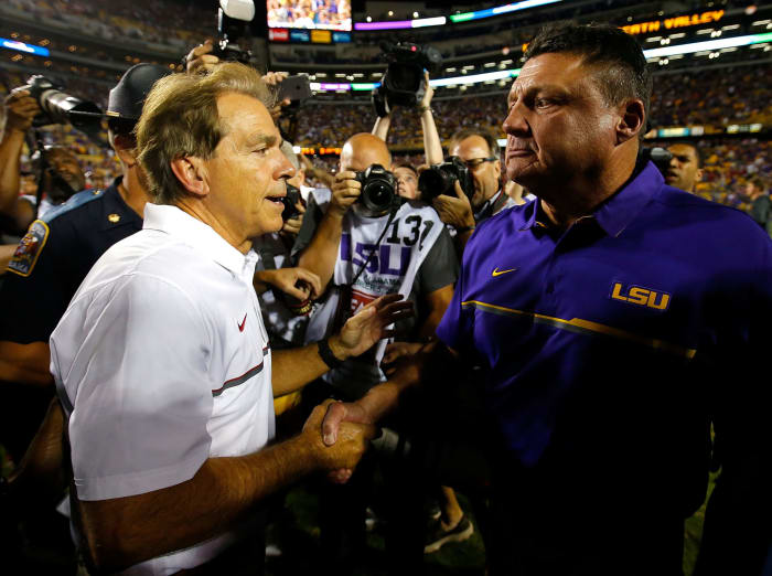 Alabama and LSU coaches Nick Saban and Ed Orgeron shake hands after a college football game.