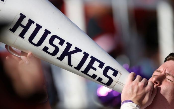 A Washington cheerleader holding a Huskies megaphone.