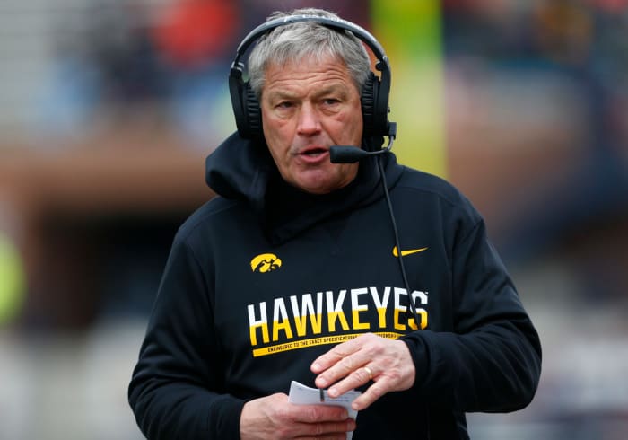 A closeup of Iowa Hawkeyes coach Kirk Ferentz wearing a Hawkeyes hoodie and a headset.