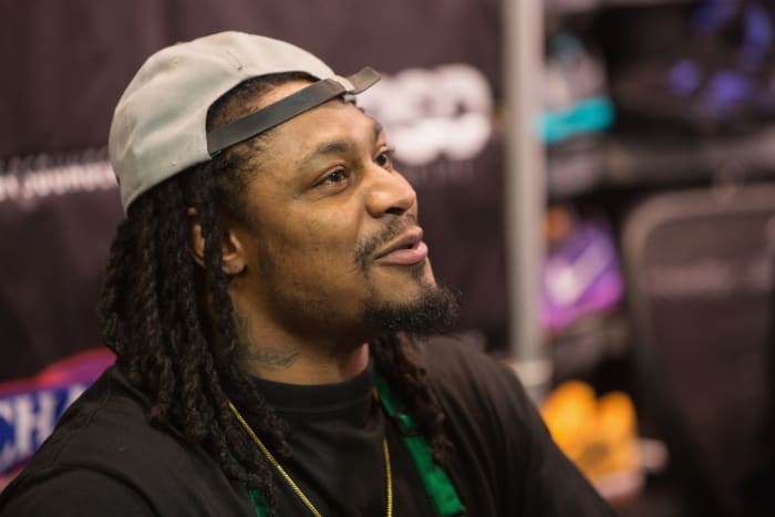 Marshawn Lynch wearing a backwards hat.