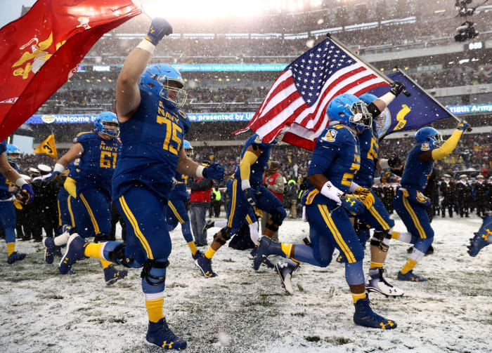 The Navy Midshipmen run out on the field before the game against the Army Black Knights in the annual Army-Navy Game in Philadelphia.
