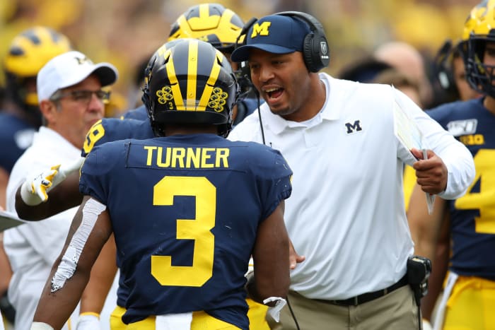 Josh Gattis celebrates with Christian Turner on Michigan football's sideline against Rutgers.