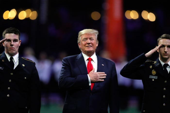 Donald Trump stands for the national anthem at the CFB Playoff.