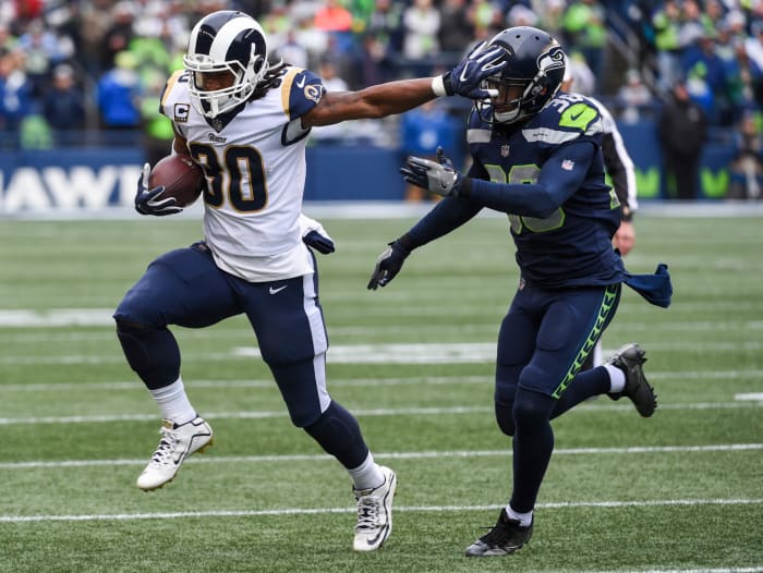 Todd Gurley giving a stiff arm to a Seahawks player.