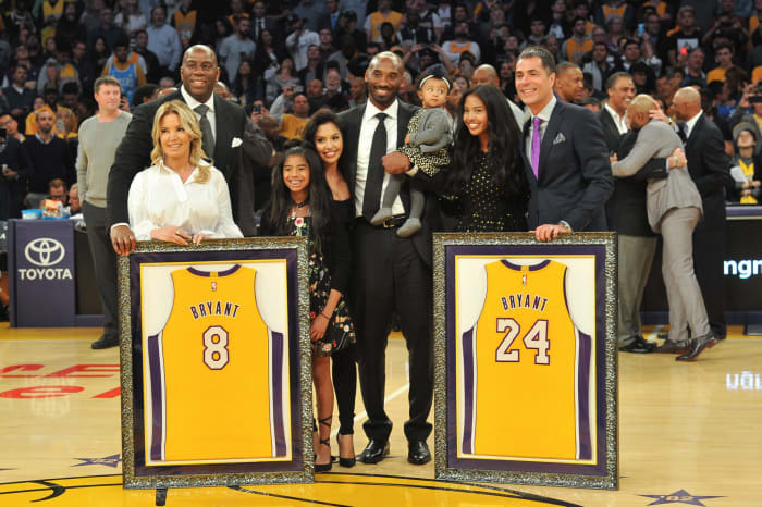 LOS ANGELES, CA - DECEMBER 18: Magic Johnson, Jeanie Buss, Kobe Bryant, wife Vanessa Bryant and daughters Gianna Maria Onore Bryant, Natalia Diamante Bryant, Bianka Bella Bryant and Rob Pelinka pose for a picture during Kobe Bryant's jersey retirement ceremony at halftime of a basketball game between the Los Angeles Lakers and the Golden State Warriors at Staples Center on December 18, 2017 in Los Angeles, California. (Photo by Allen Berezovsky/Getty Images)