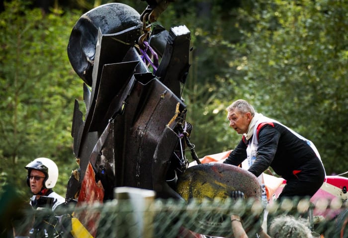 Officials remove the car of Anthoine Hubert from the track.