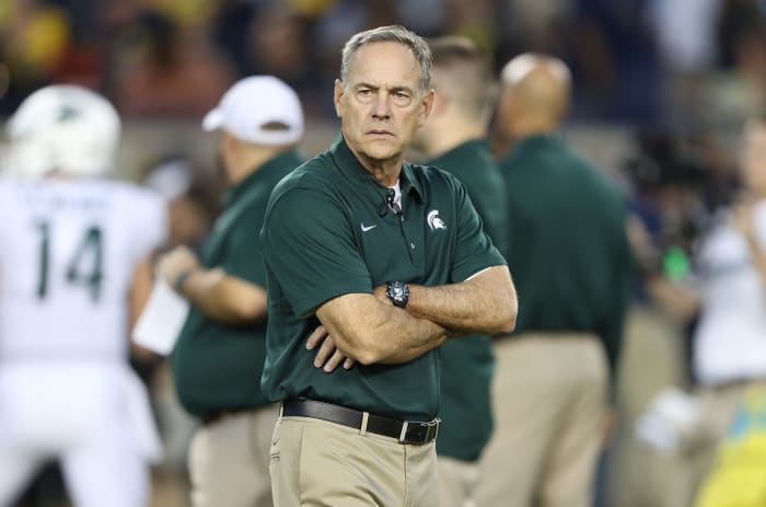 A closeup of Mark Dantonio wearing a green Michigan State polo.