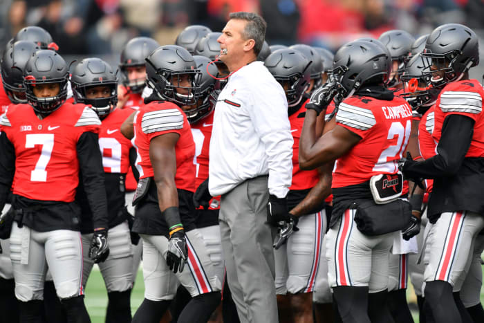 Urban Meyer standing with Ohio State Buckeyes players before a game.