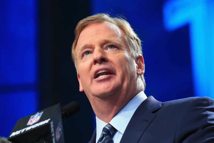Roger Goodell talking at a podium at the NFL draft.