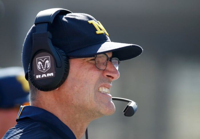 Jim Harbaugh winces as he looks on from the sideline.
