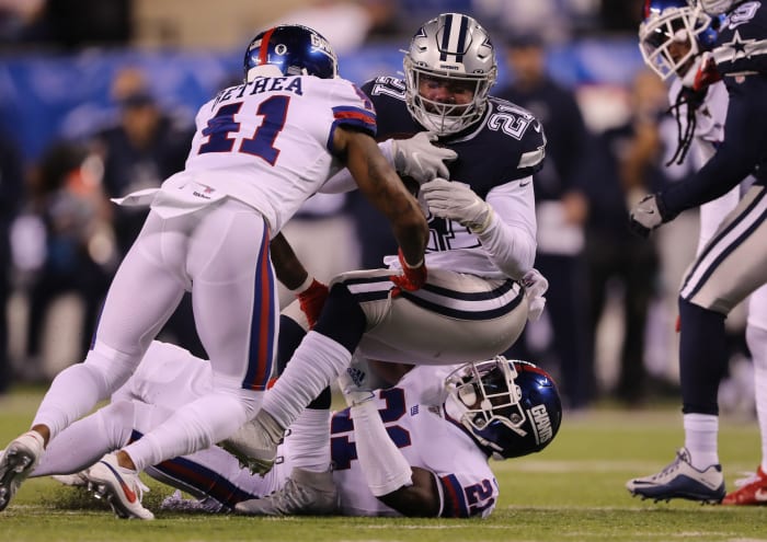 Giants safety Antoine Bethea tackles Ezekiel Elliott during a game.