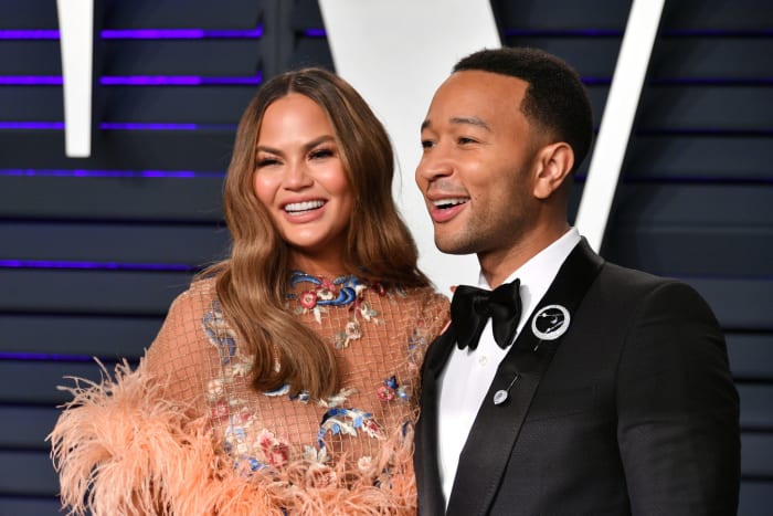 John Legend posing for a photo with his wife Chrissy Teigen.