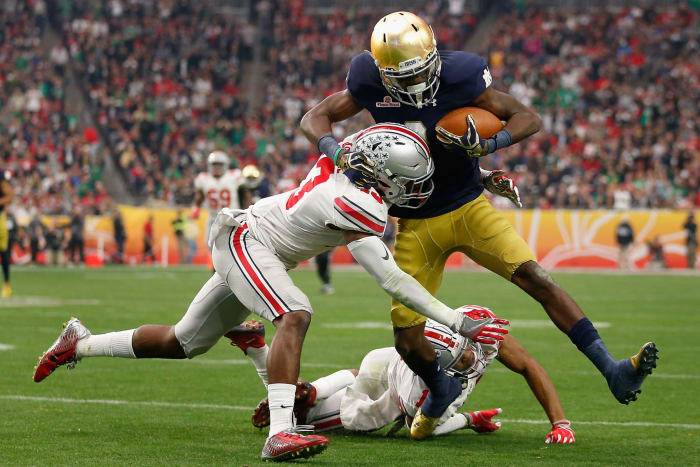 An Ohio State player tackling a Notre Dame player.