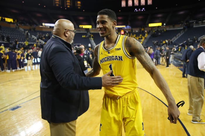 Michigan AD Warde Manuel congratulates Charles Matthews after a game.