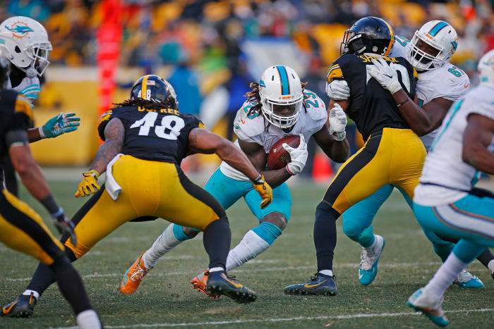Steelers players tackle Dolphins running back Jay Ajayi.