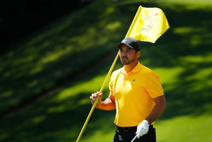 Jason Day holds the flag.