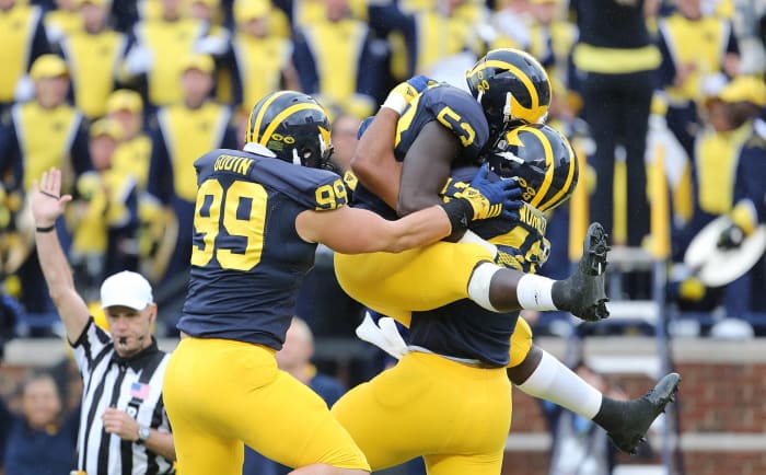 Michigan Wolverines football players celebrating a sack.