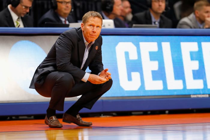 Mark Few crouching at center court.