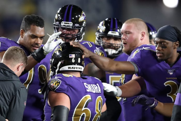 Ravens players pat center Matt Skura on the helmet.