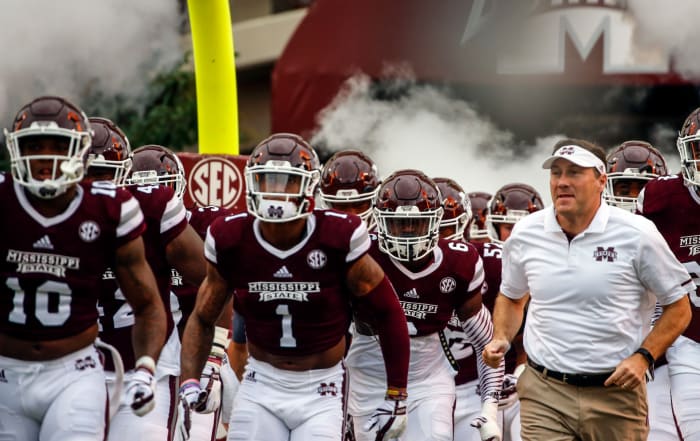 Dan Mullen leading his Mississippi State players onto the field.