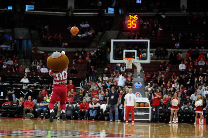 Ohio State's mascot taking a half court shot during a basketball game.