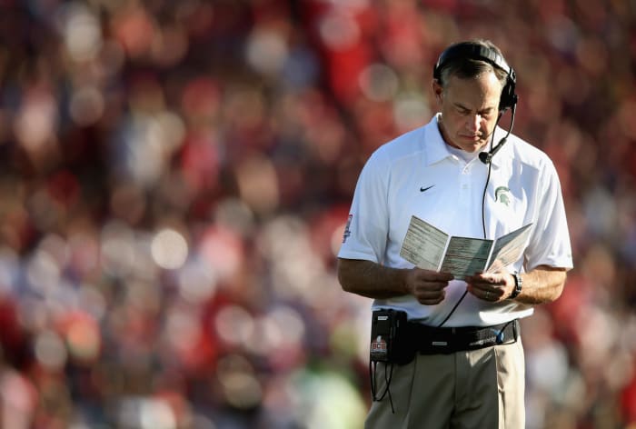 A closeup of Mark Dantonio looking at his play sheet.