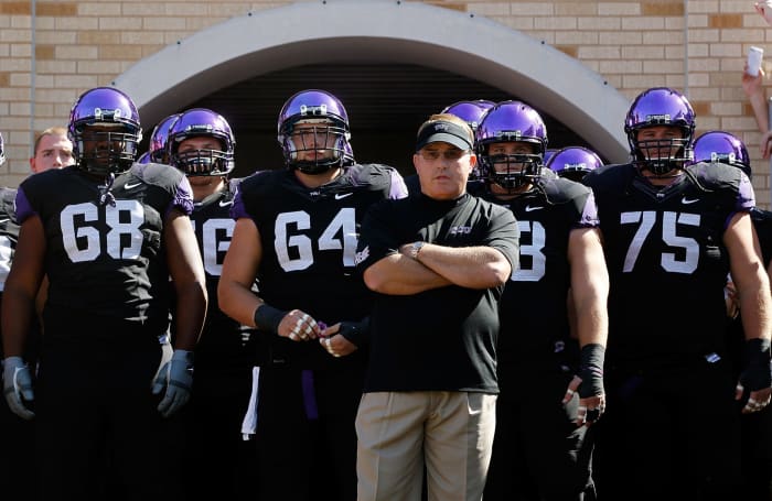 Gary Patterson leading his TCU football team onto the field for a Big 12 football game.