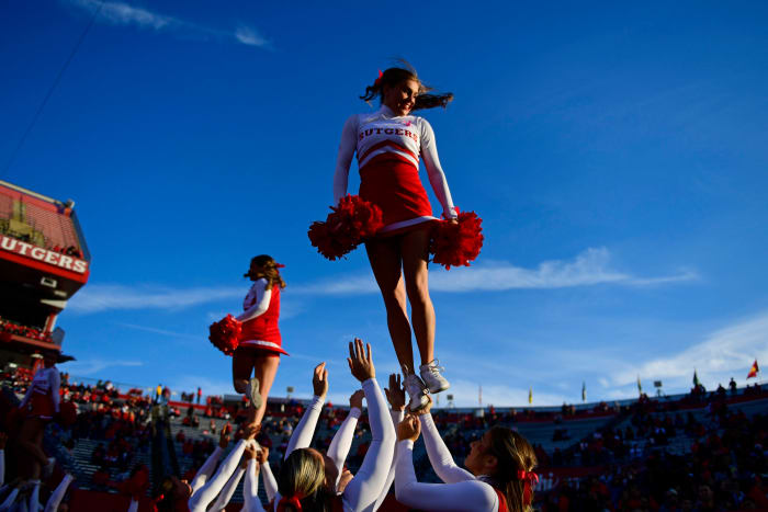 Rutgers cheerleaders celebrate on the field against Minnesota.