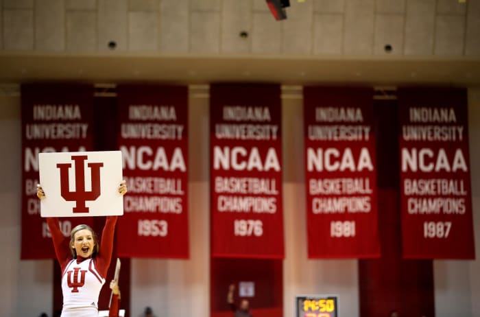 An Indiana cheerleader holding a sign during a basketball game.