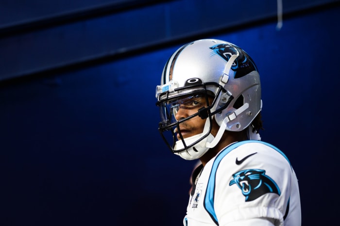 Cam Newton walks into a game against the Patriots.