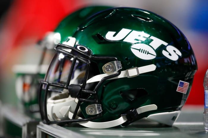 A picture of two Jets helmets sitting side-by-side.