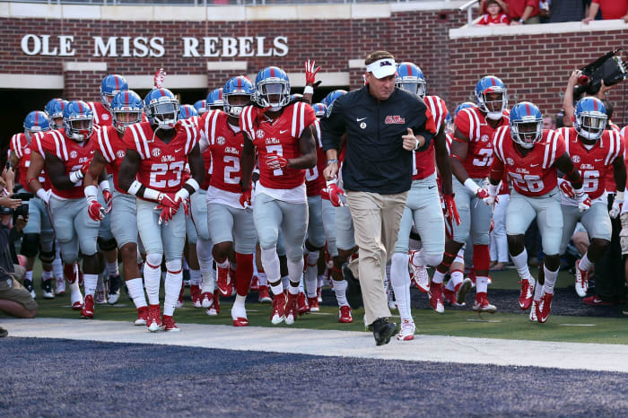 Hugh Freeze leading the Ole Miss football team onto the field.