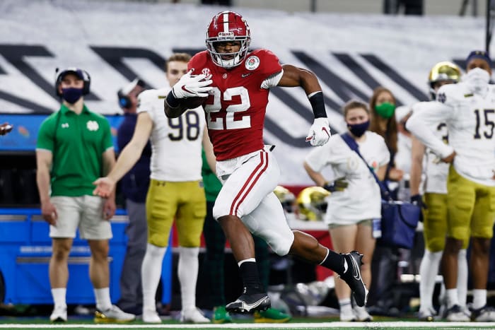 Najee Harris runs past a defender.