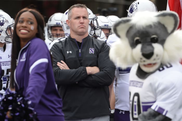 Northwestern coach Pat Fitzgerald leading his team onto the field.