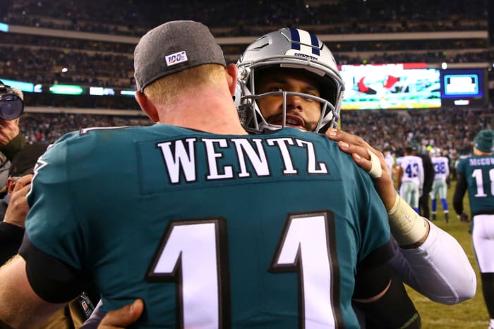 Carson Wentz and Dak Prescott shake hands and hug following a game.