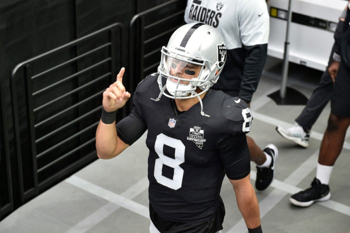 Raiders quarterback Marcus Mariota points to the sky while walking.