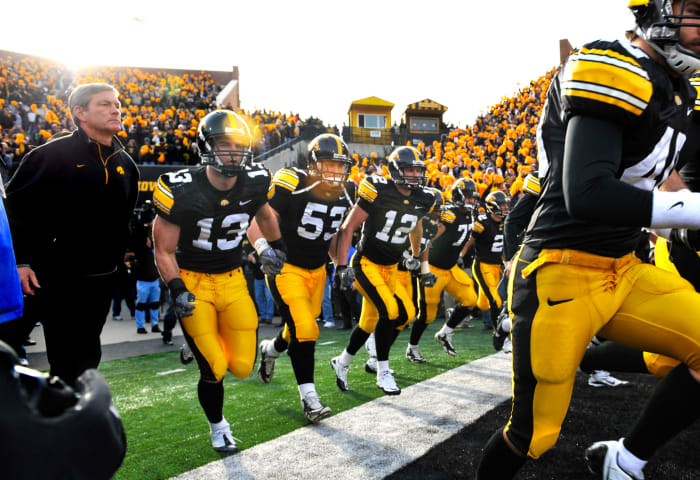 Iowa football coach Kirk Ferentz runs onto the field before a Big Ten game against the Ohio State Buckeyes.