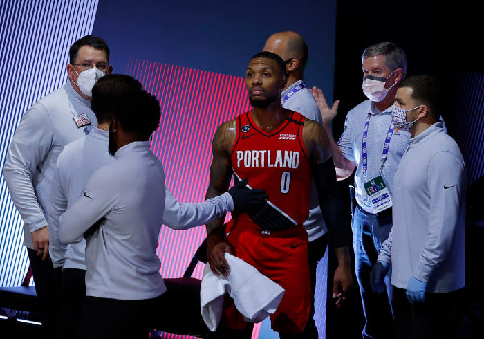 Damian Lillard surrounded by trainers.