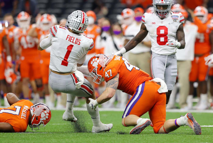 Ohio State quarterback Justin Fields takes a hit from James Skalski.