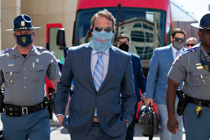 Lane Kiffin wearing a suit walking into a stadium before a game.