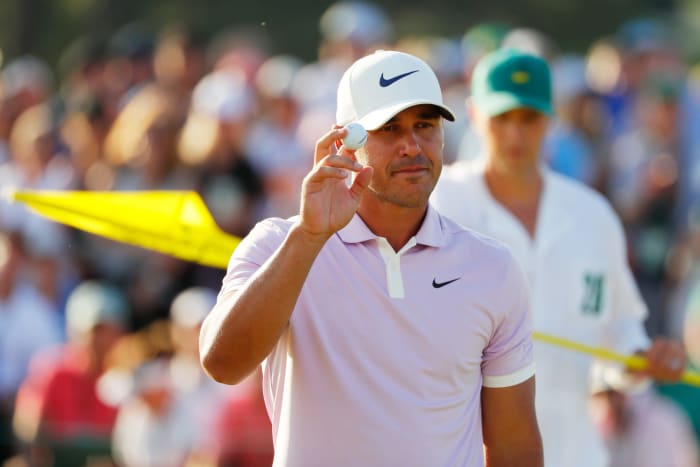 Brooks Koepka acknowledges patrons after putting on the 18th green.