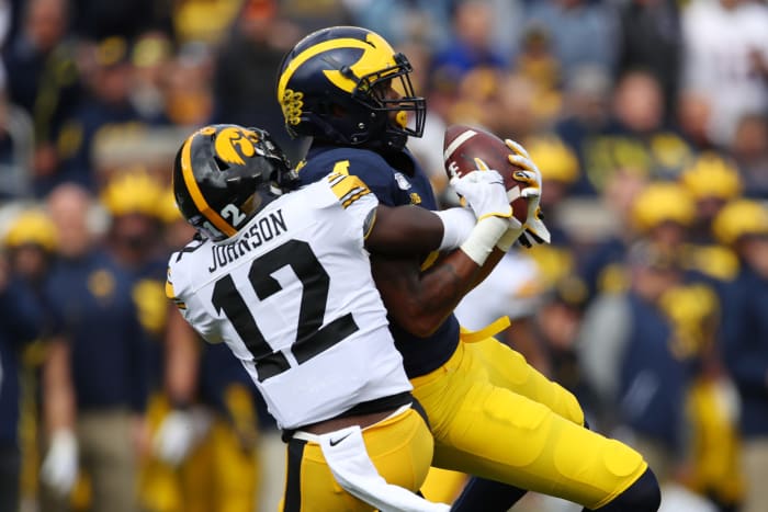 Iowa's DJ Johnson tackles Michigan's Nico Collins.
