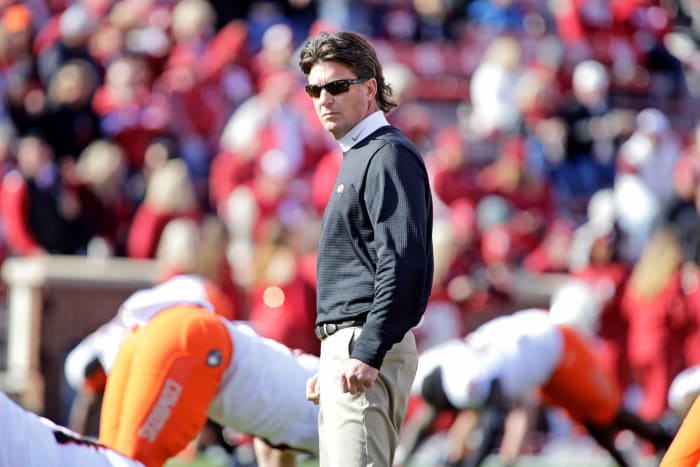 Mike Gundy watching his players warm up before an Oklahoma State football game.