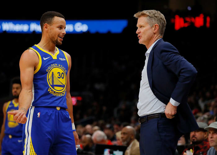 Steph Curry #30 and Steve Kerr of the Golden State Warriors converse