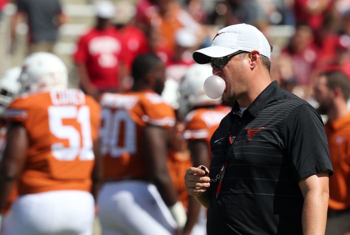 A closeup of Texas football coach Tom Herman blowing a bubble.